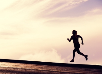 Female athlete sprinting up a hill, representing overtraining linked to muscle dysmorphia (bigorexia).